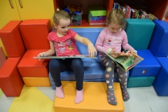 Dziewczynki w przedszkolu oglądają książeczki związane z ekologią.